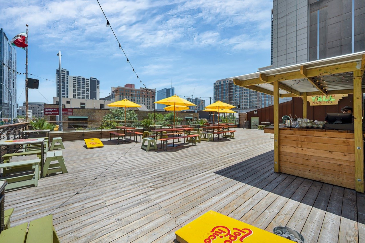 El Cockfight exterior rooftop patio, cornhole and umbrellas